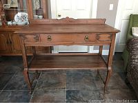 Full front view of the entry table showing the drawer, lower shelf, and leg design.