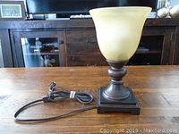 10-inch smoke glass shade lamp with dark base and electrical cord on wooden table, front angle