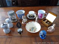 Full lot overview showing mason jar, figurines, porcelain items, grinder set, compass, and tea cup.