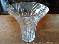 Front angled view showing the flared shape and cut pattern of the vase on a wooden surface.