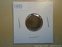 Obverse side of 1905 Indian Head Penny showing Liberty wearing a Native American headdress within white cardboard holder labeled '1905'.