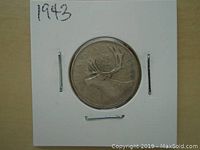 Front image of 1943 Canadian silver 25 cents coin with caribou design and date above