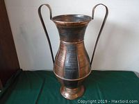 Image of the 25-inch retro metal vase showing front view with two tall curved handles and hammered copper and dark metal finish.