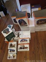 Overview of boxed Department 56 Snow Village Halloween pieces with styrofoam inserts and outer packaging.