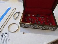Photo of the sterling silver jewelry including bracelets, necklace, ring, and the ornate jewelry box with many smaller pieces inside.
