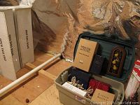 Lot contents showing storage bin with assorted holiday decor including boxes, angel figurines, and wood cutout