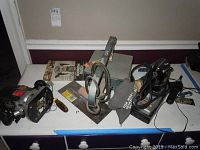 Photo showing multiple items on a table including routers, trowel, screwdriver, and a sanding block.