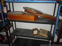 Wooden octagonal wall clocks and two tabletop clocks on shelves