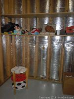 Photo showing sports themed end table with painted basketball, soccer, and baseballs, along with various items on a shelf and floor