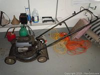 Side view of the Murray Select lawn mower with 22 inch deck, showing the handle and four outdoor extension cords coiled on the ground next to it.