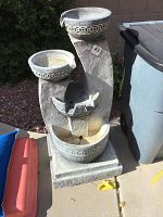 Front and side view of the four-bowl electric fountain showing the textured base and decorative carved edges on each bowl.