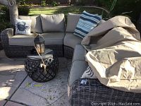 Overall view of L-shaped sectional sofa with cushions and square wicker end table