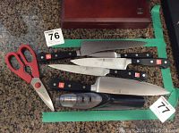 Full set of three knives, kitchen shears and sharpener on countertop