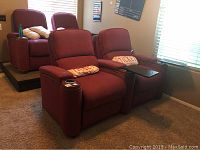 Front view of two red theatre seats side by side in a room