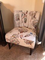 Front and side view of printed fabric accent chair with floral pattern upholstery and vertically channeled backrest.