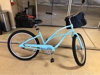 Full side view of light blue Electra beach cruiser with black handlebar bag