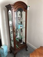 Full-height view showing wooden frame, arched top, glass sides and interior contents (not included)