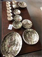 All pieces laid out on table: cups, saucers, plates, bowls, sugar bowl and cream pitcher