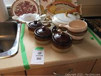 Lot contents shown on kitchen counter including soup bowls, tureen, Murano glass dish, and ceramic bowls.