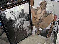 Two 25x37 inch framed Marilyn Monroe posters and standing Marilyn Monroe wall clock with size noted.