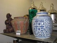 Photo showing all four decorative items including elephant figurine, pottery planter, blue and white pottery jar, and green glass vase