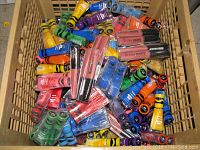 Basket containing assorted new Sally Hansen Crayola Insta-Dri nail polishes and Stay Matte liquid lip colors randomly arranged showing variety of colors and packaging design.