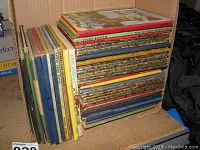 Box with a large stack of over 40 vintage Wonder Books in various sizes and colors, showing tops and spines of many titles.