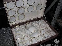 View of the full tea set including cups, saucers, teapot, creamer, and sugar bowl placed in satin-lined box showing condition and presentation