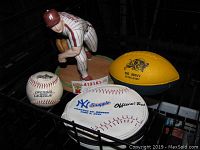 Entire lot showing Steve Carlton ceramic figurine, Rawlings baseball, Snapple NY Yankees baseball-shaped CD case, and yellow navy Go Navy Bomb Army football