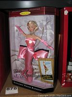 Full front view of Barbie as Marilyn Monroe doll in display case showing pink dress and packaging