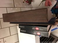 Two black 1981 Scott Standard Postage Stamp Catalogs (Vol. 2 & Vol. 4), a blue binder and a wooden box stacked