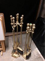 Two full sets of fireplace tools each with a brass finish stand and four tools (poker, tongs, brush, shovel).