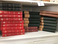 Shelf with multiple sets of hardcover classic novels and bound magazines.