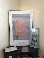 Framed Paul Klee poster with abstract design, framed troll illustration print, framed recipe art, and framed vintage photo on black table