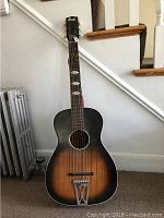 Front view of Stella acoustic guitar with sunburst finish and steel reinforced neck.