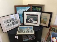 View of six framed artworks featuring various scenes including sailboats, flowers, and still-life