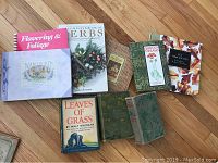Top-down view of the 10 books laid out on a wooden floor showing various gardening and literary titles.