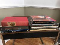 Photo showing a stack of art books on a wooden surface, titles include David Hockney, Graham Sutherland, Expressionism, Edward Munch, Central European Avant-Gardes, De Stijl.