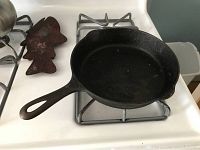 Top view of a vintage cast iron skillet showing the cooking surface and long handle.