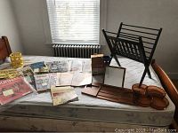 Entire lot including magazines, tray, coasters, mirror, magazine rack, and vinyl record box displayed on a bed mattress.