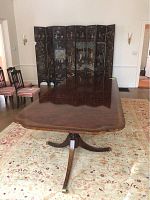 Full length table with decorative folding screen backdrop, showing double pedestal base and tabletop shape