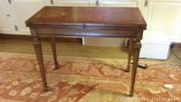 Side view of the rectangular wooden gateleg library table with folding top down, showing the straight tapered legs and medium brown finish.