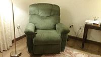 Front view of green upholstered recliner chair in upright position