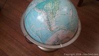 Globe showing South America and Antarctica with a metal center rim and base.