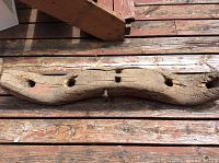 Top view of the wooden yoke showing three large holes and aged wood grain
