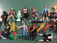 Wide view showing the full assortment of figures and accessories on a green cloth background.