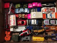 Box containing assorted vintage toy vehicles including shell tanker, racing cars, emergency vehicles