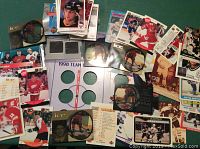 Photo shows a spread of assorted hockey cards including player cards, a 1998 coin set card holder, and cards with images of Wayne Gretzky.