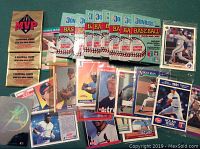 Unopened packs of Donruss MVP Blue Jays Gold Series baseball cards alongside loose individual cards featuring baseball players, some in sleeves, one holographic.