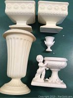 Top view of two square urn-style vases, tall fluted vase, small urn, and cherub with planter
